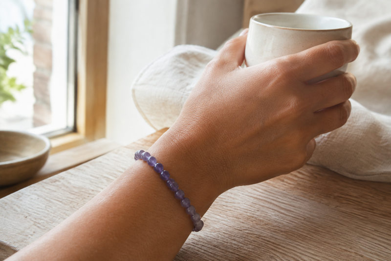 Amethyst bracelet worn while holding a ceramic cup